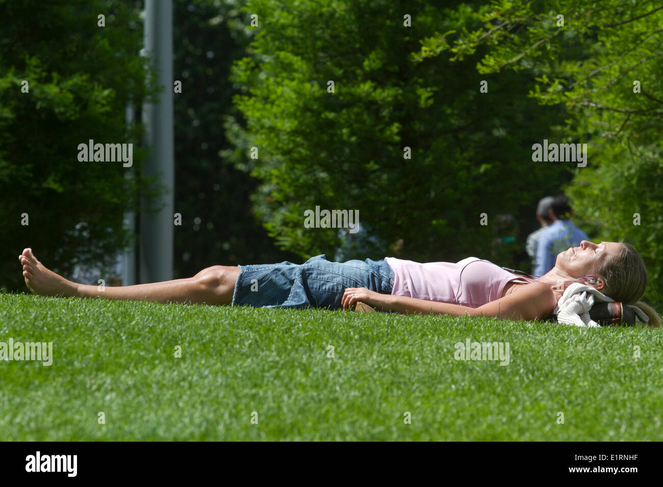 Londra, Regno Unito. Il 9 giugno 2014. Una donna a prendere il sole sul prato come il clima caldo e in estate arriva finalmente il credito: amer ghazzal/Alamy Live News Foto Stock