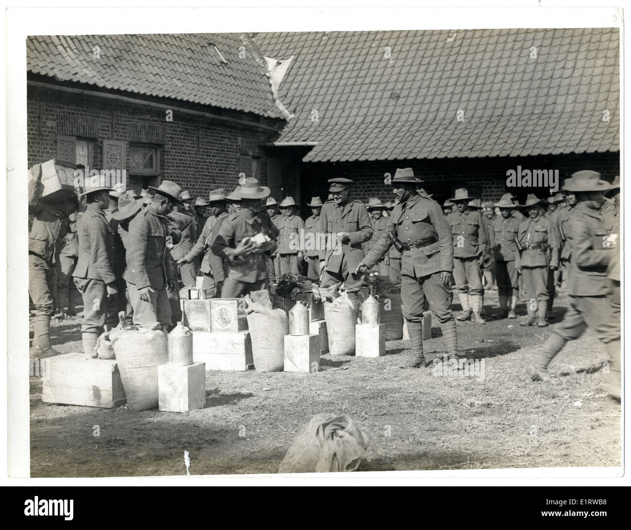 L'immagine mostra i membri del 9° Gurkha che disegnano razioni in una fattoria francese a St Floris, in Francia, durante la prima guerra mondiale. La fotografia cattura un momento di vita quotidiana per i soldati sul campo, riflettendo i loro doveri e le loro interazioni durante la guerra. Foto Stock