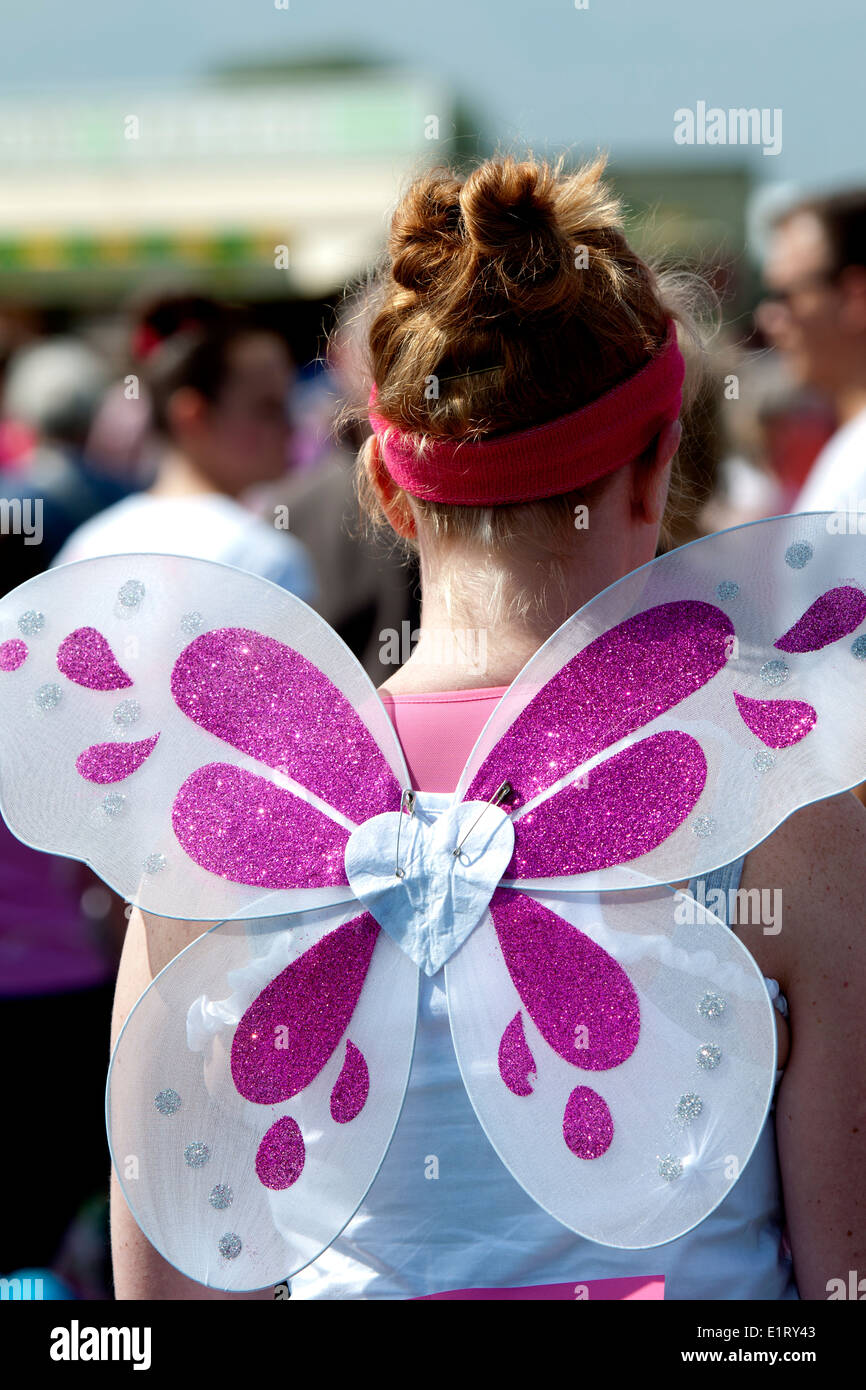 Gara per la vita, Cancer Research UK evento di beneficenza, donna che indossa le ali delle farfalle. Foto Stock