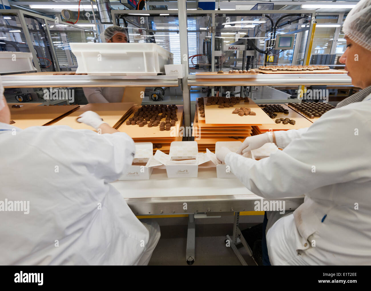 Lavoratori presso lo Swiss la fabbrica di cioccolato di Lindt & Spruengli in Zurigo / Kilchberg sono operazioni di cernita e di imballaggio di cioccolatini. Foto Stock