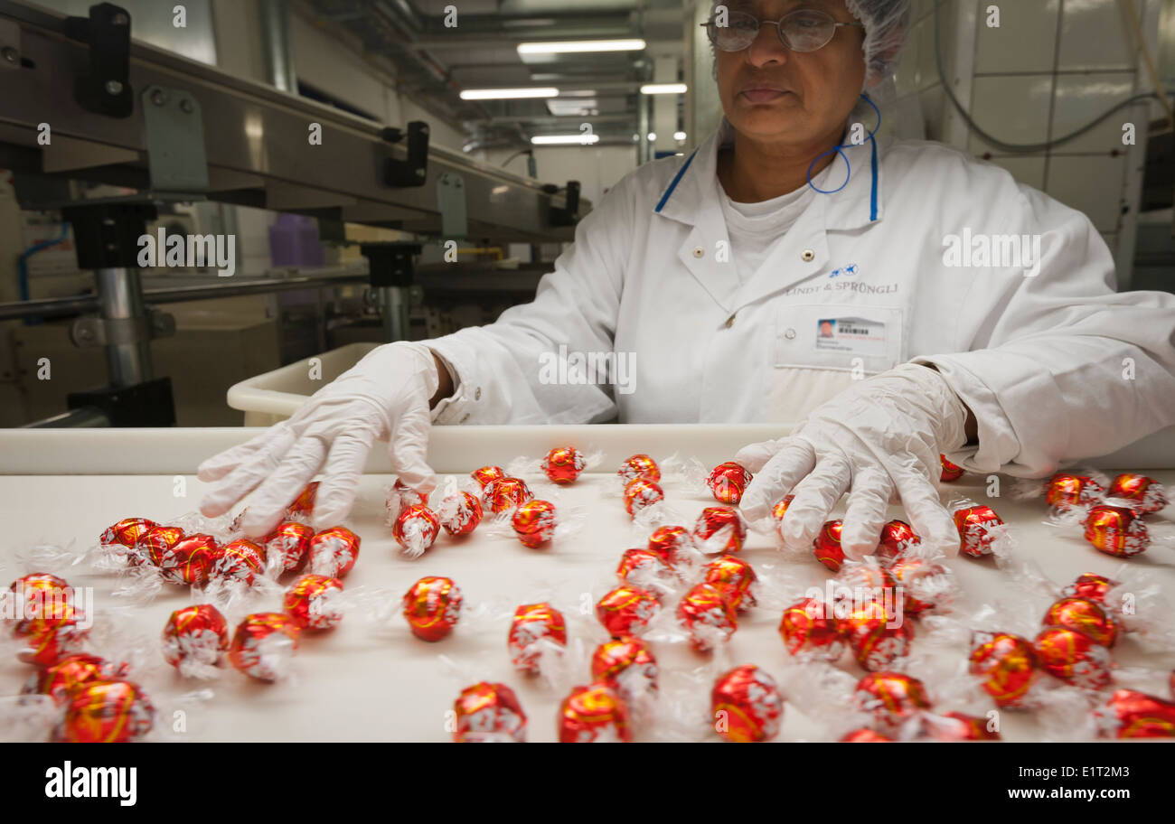 Un lavoratore presso lo Swiss la fabbrica di cioccolato di Lindt & Sprungli a Zurigo/Kilchberg è di ispezionare la produzione di 'Lindor' caramelle Foto Stock