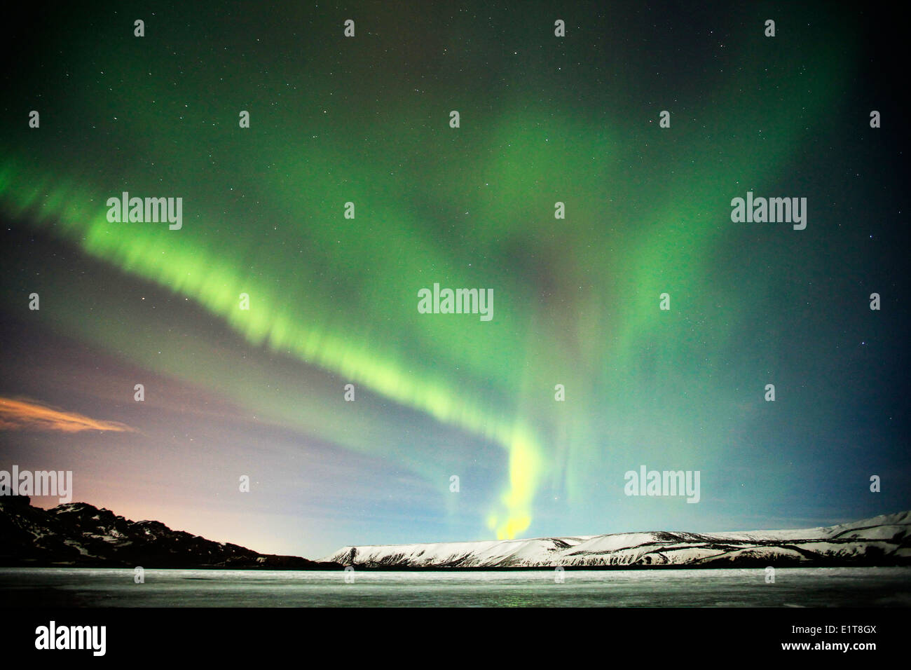 Le luci del nord brillano al di sopra di un lago ghiacciato al di fuori di Reykjavik in Islanda Foto Stock