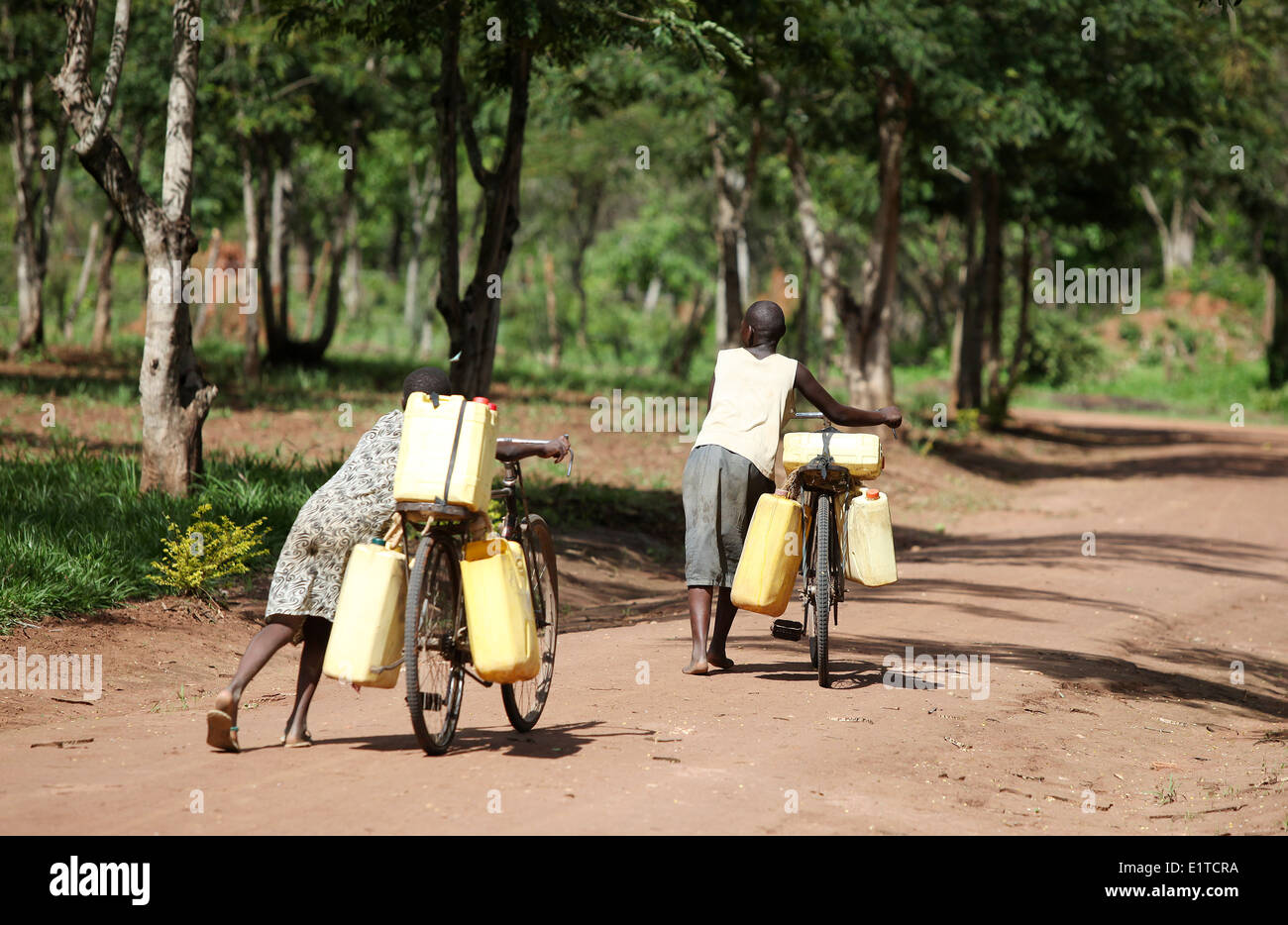 I bambini raccolgono acqua sulle loro moto nella regione di Nakasongola di Uganda Foto Stock