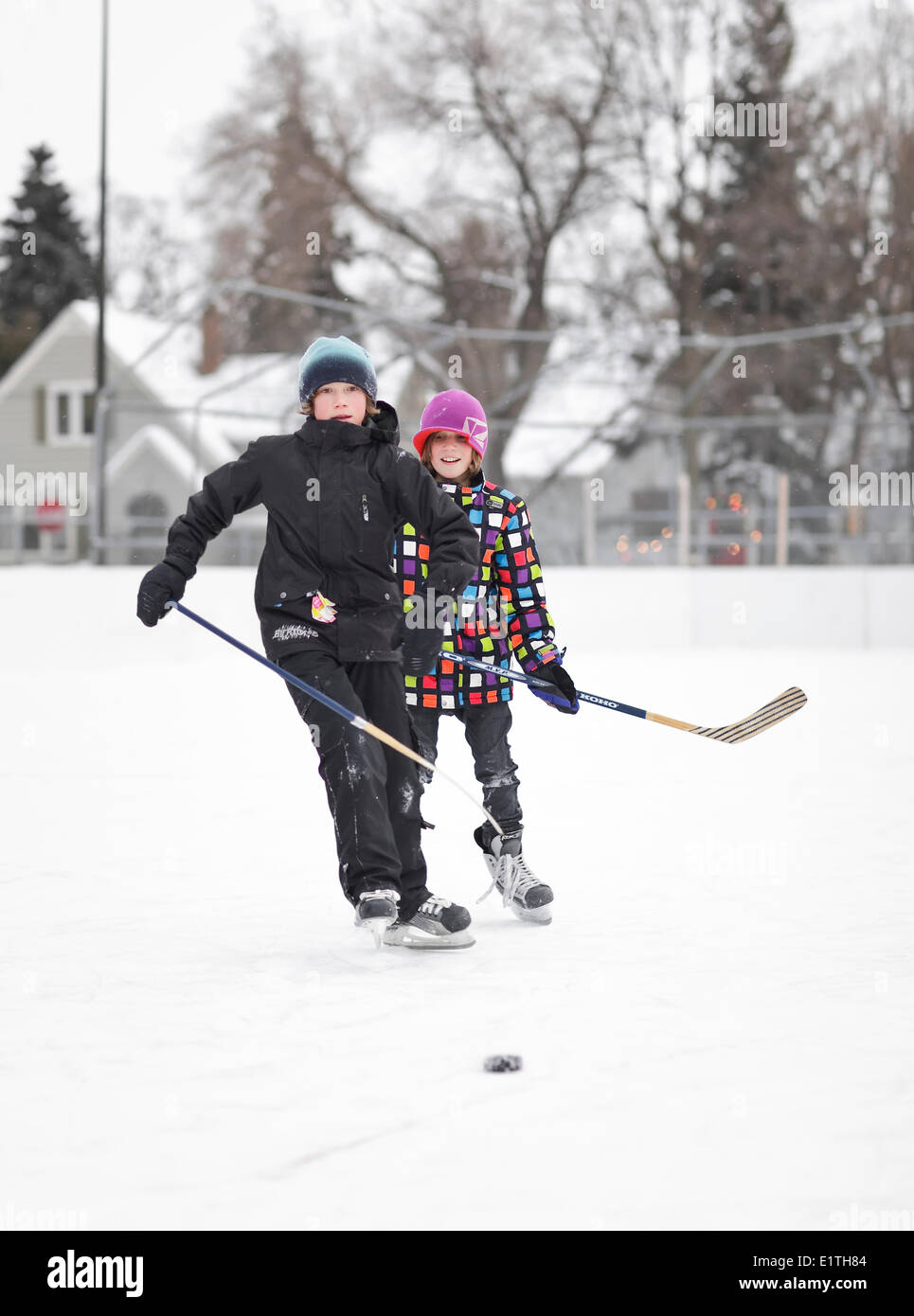 Ragazzi giocare hockey su ghiaccio, su un quartiere outdoor rink, Winnipeg, Manitoba, Canada Foto Stock
