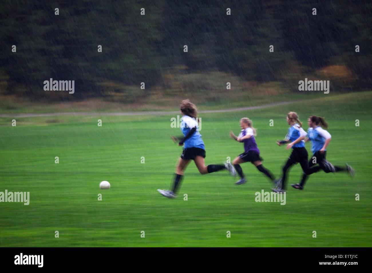 La ragazza Soccer, pioggia, sport di squadra, l'attività fisica, la salute, Gibson, Sunshine Coast, B.C., Canada Foto Stock
