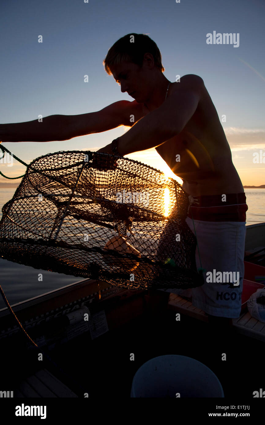 Impostazione della gioventù trappole di gamberi, la pesca e il canottaggio, calma, estate, Tramonto, Savary Island, stretto di Georgia, Sunshine Coast, B.C., Canad Foto Stock