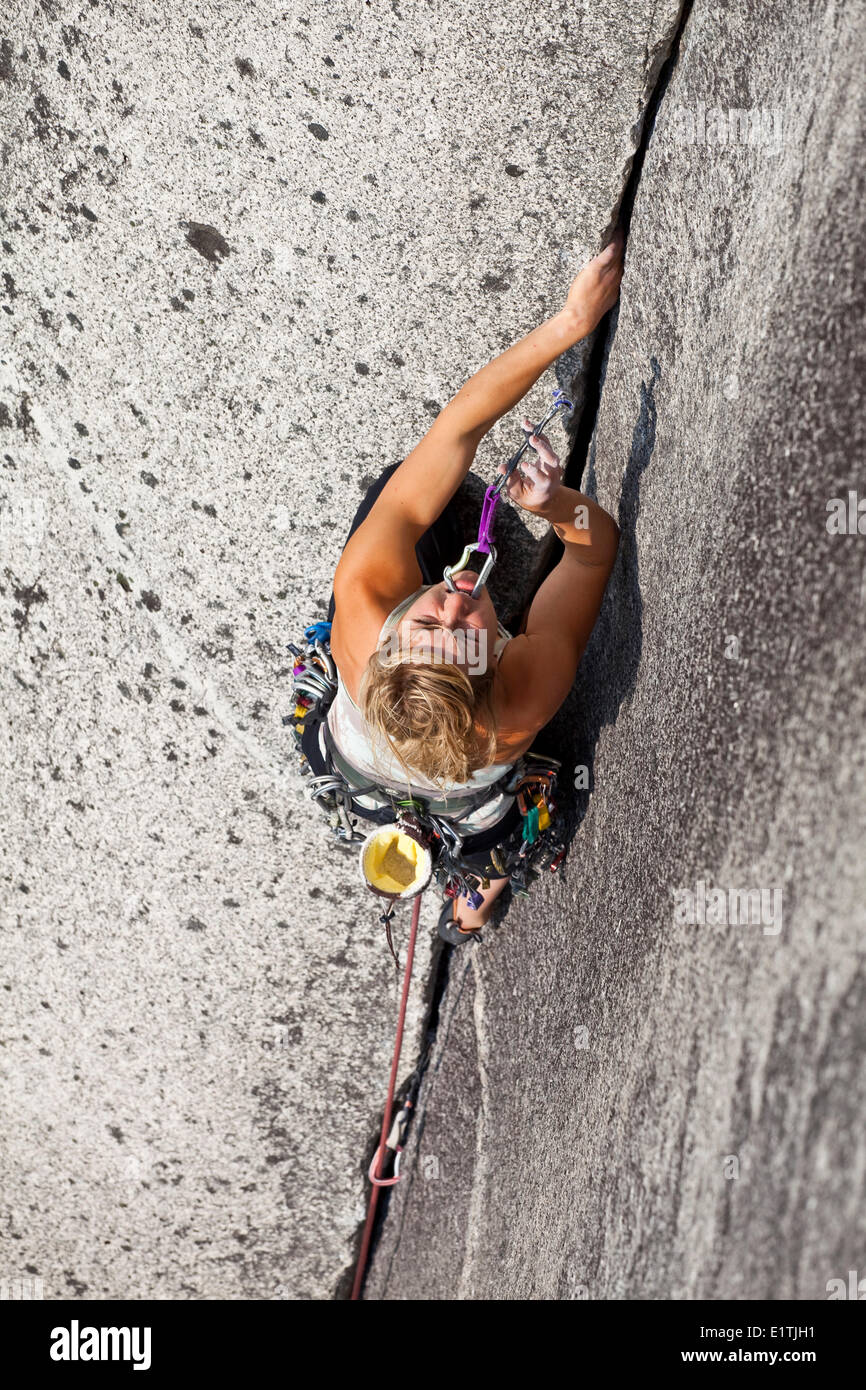 Un forte scalatore femmina climbing Crescent Crack 10d, Squamish, BC Foto Stock