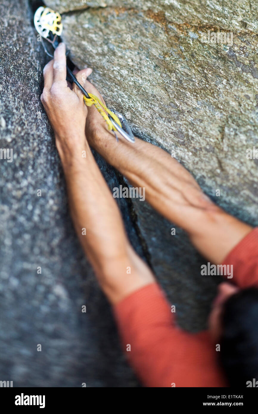Un forte scalatore maschio si arrampica su un angolo di crack, Caboose 10b, Squamish, BC Foto Stock