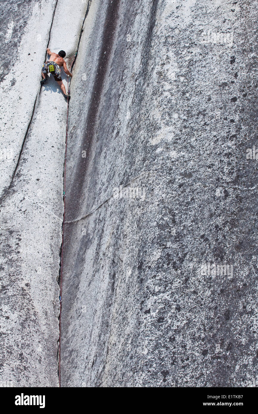 Un forte scalatore maschio della mezzaluna di arrampicata Crack 10d, Squamish, BC Foto Stock