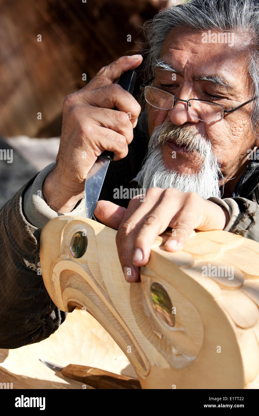 Una delle prime nazioni carver che lavora su un pezzo di Eagle, scolpite da giallo cedro, Tofino, Isola di Vancouver, British Columbia, Canada Foto Stock