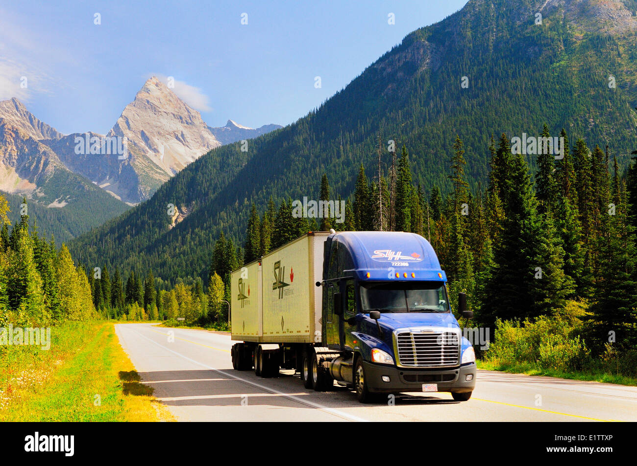 Un carrello di trasporto merci cale lungo la Trans Canada Highway nel Glacier National Park Foto Stock