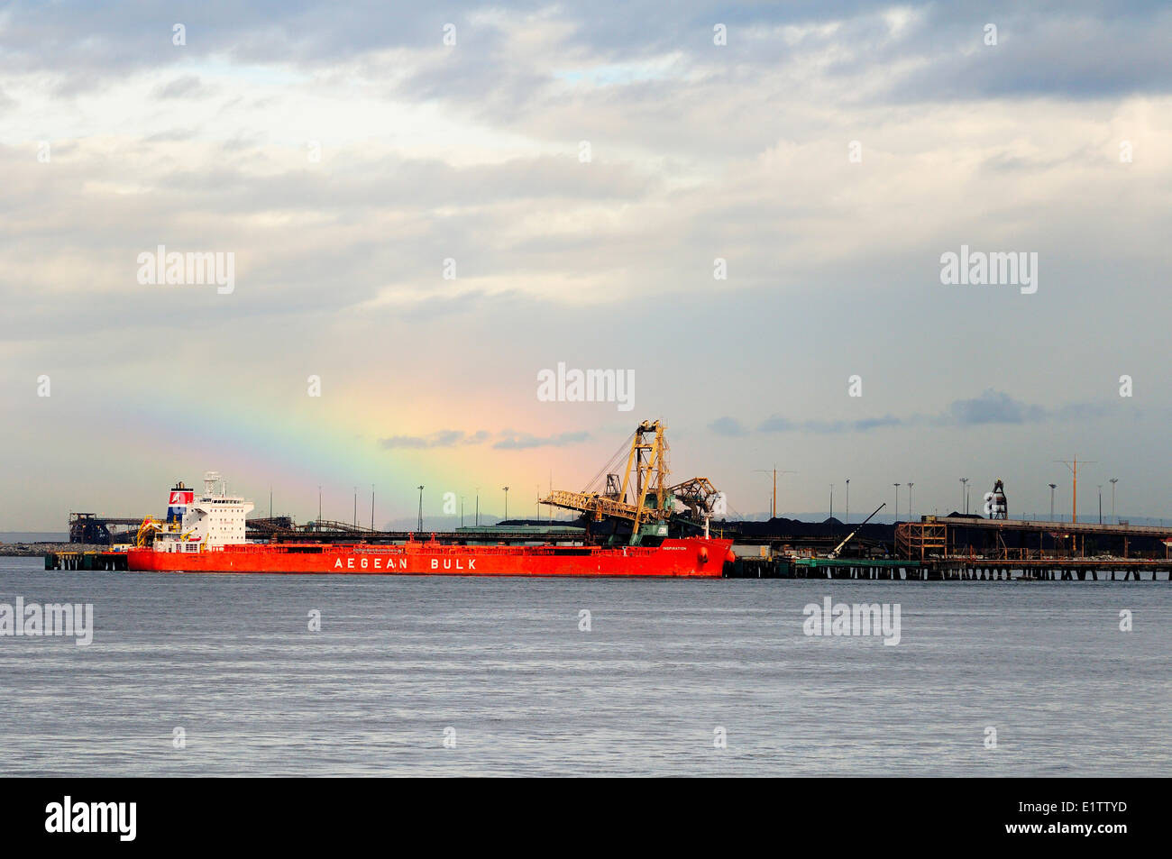 Un arcobaleno si appoggia sopra il cargo ispirazione, come si carica il carbone a Roberts Bank vicino a Tsawwassen, BC. Foto Stock