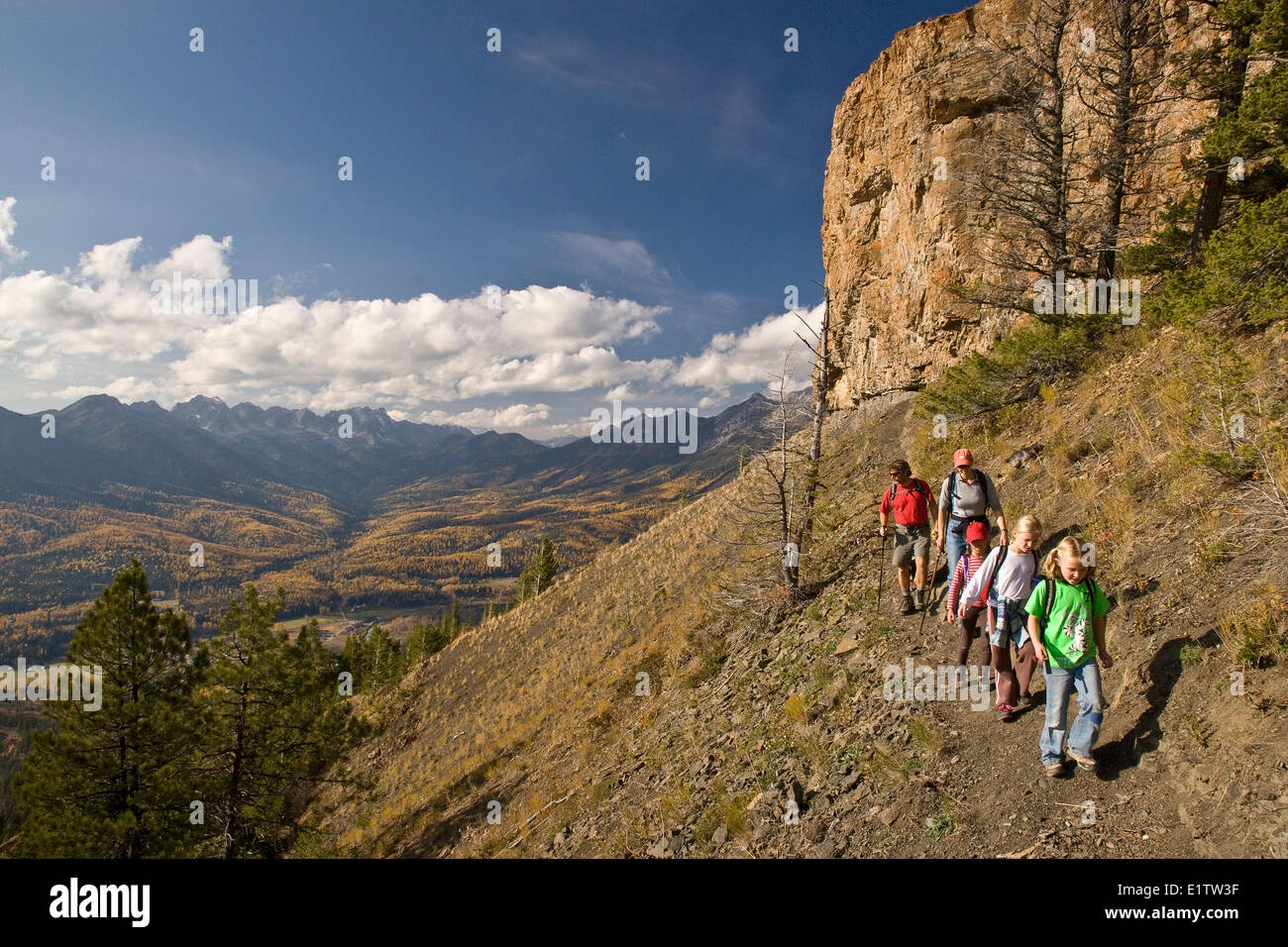 Giovane famiglia escursioni sul castello sentiero di montagna in autunno, Fernie, BC, Canada. Foto Stock