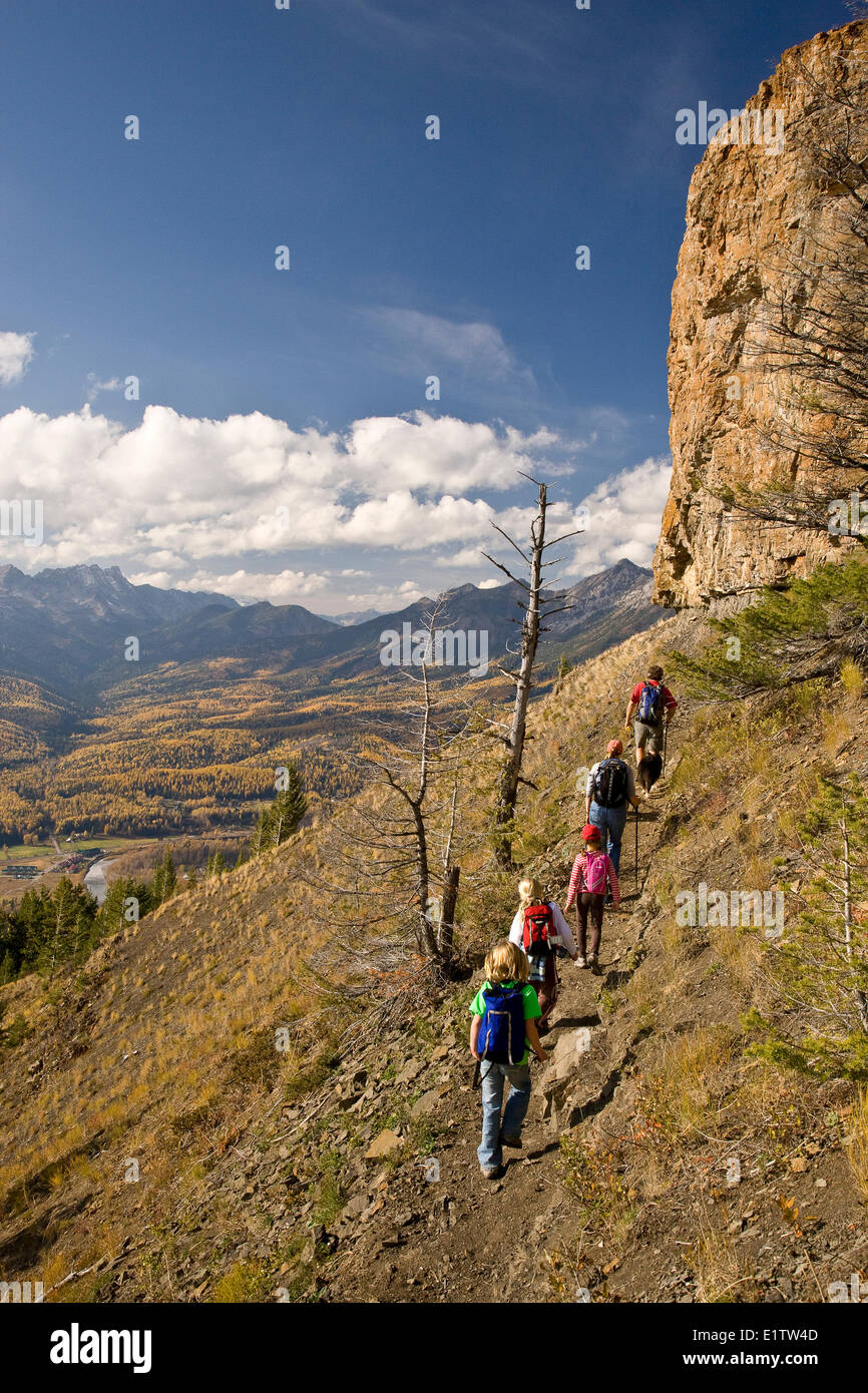 Giovane famiglia escursioni sul castello sentiero di montagna in autunno, Fernie, BC, Canada. Foto Stock