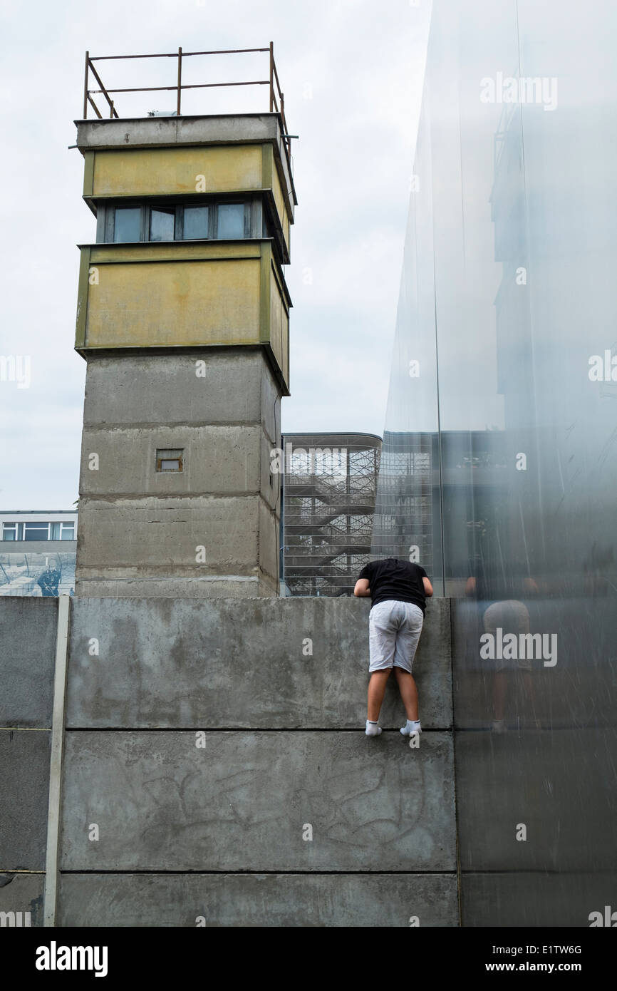 Ragazzo cerca nella ex morte striscia di muro di Berlino su Bernauer Strasse Berlino Germania Foto Stock