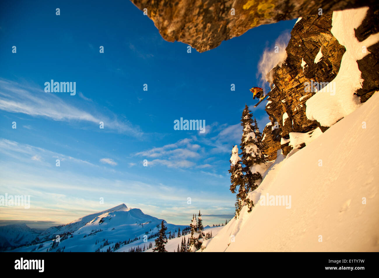 Un maschio di backcountry rider scende una scogliera mentre fuori lo sci alpinismo, Sol Mountain, Monashee Backcountry, Revelstoke, BC Foto Stock