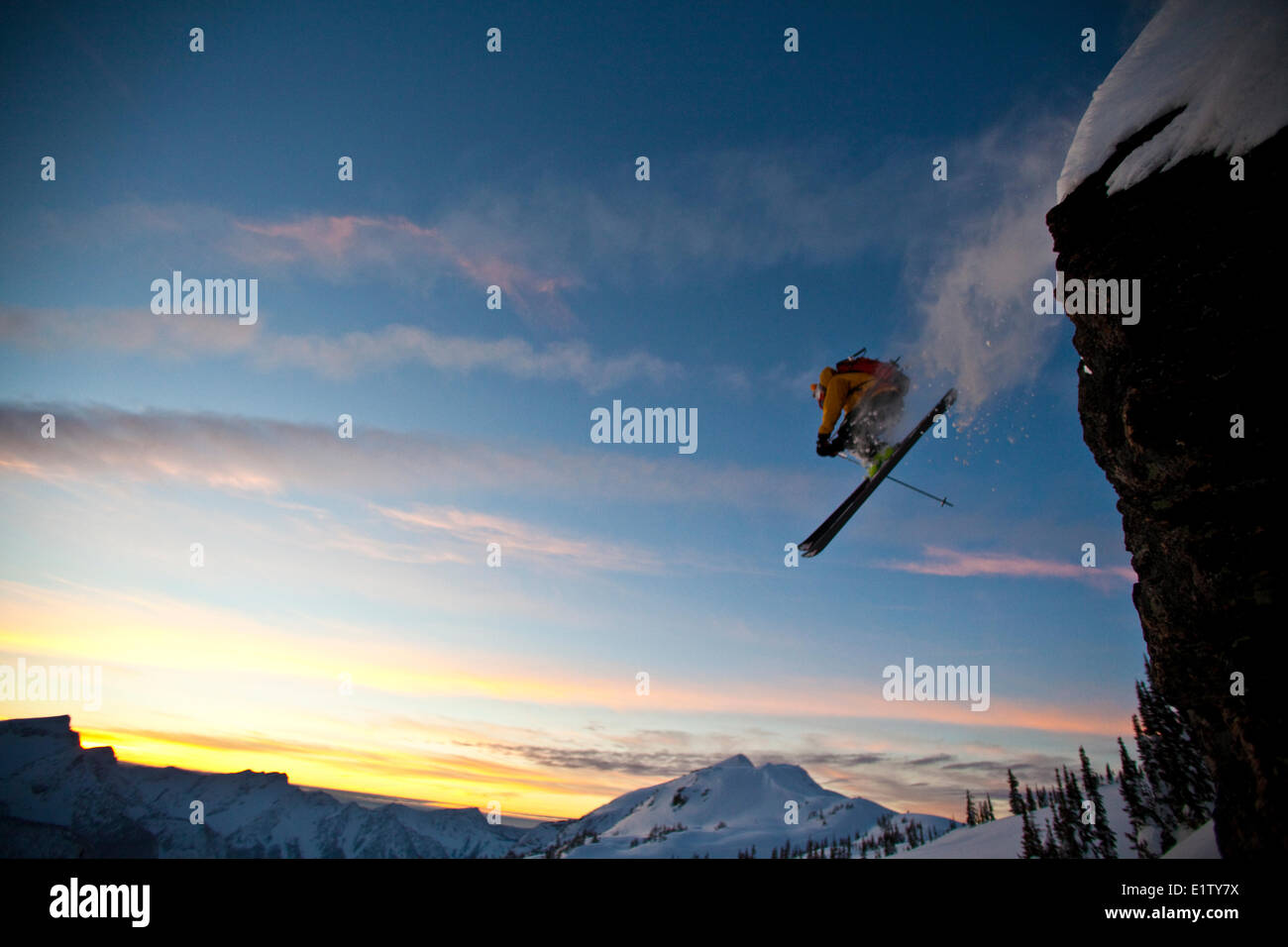 Un maschio di backcountry rider scende una scogliera mentre fuori lo sci alpinismo, Sol Mountain, Monashee Backcountry, Revelstoke, BC Foto Stock