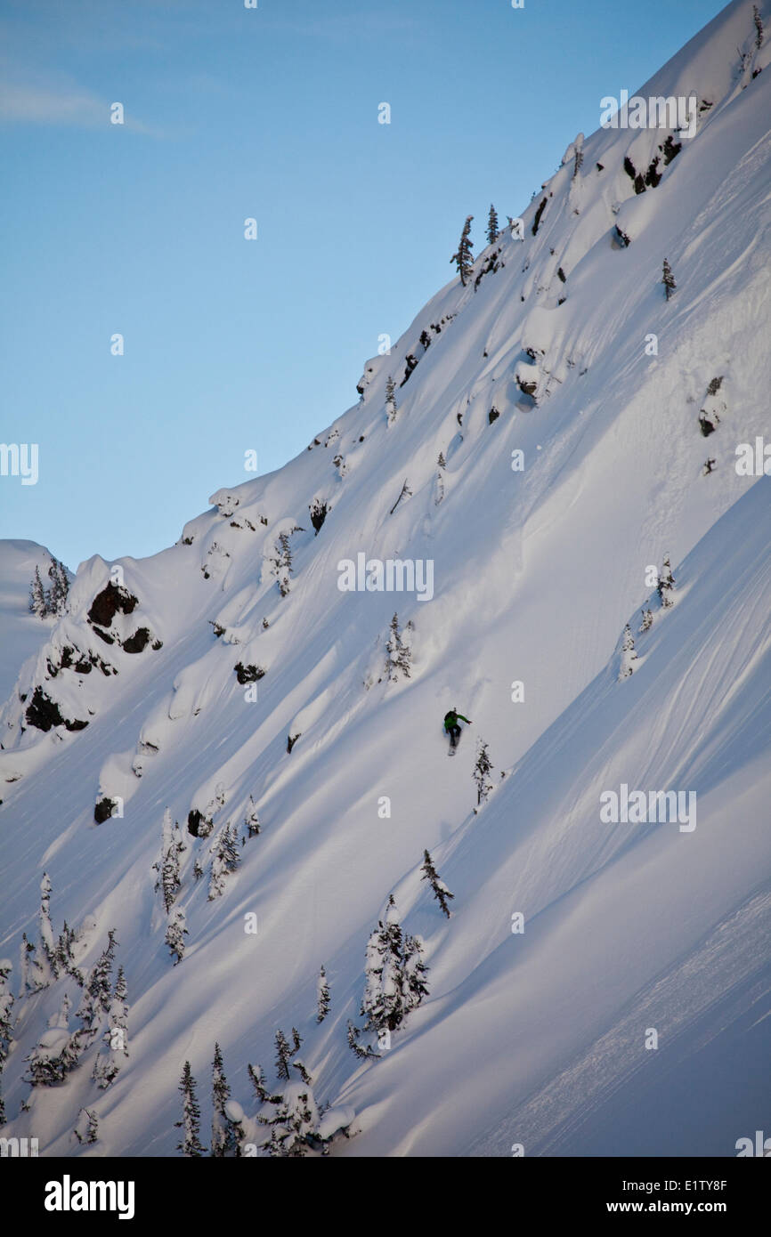 Un maschio di backcountry snowboarder spruzzi alcuni polvere nell'Revelstoke Mountain Backcountry, BC Foto Stock