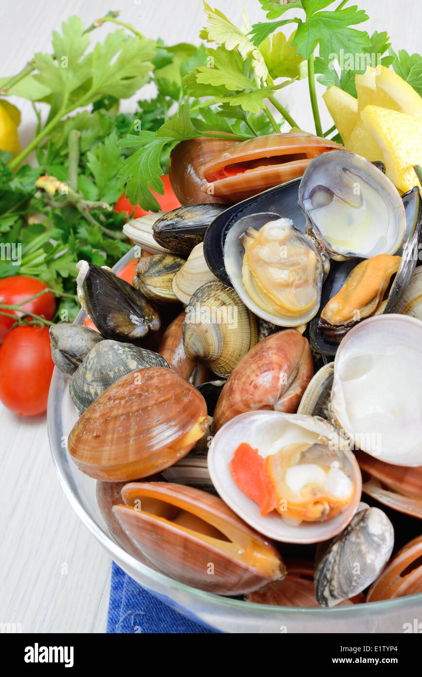 Materie frutti di mare chiamato fasolari vivono ancora con limone e spaghetti ingredienti Foto Stock