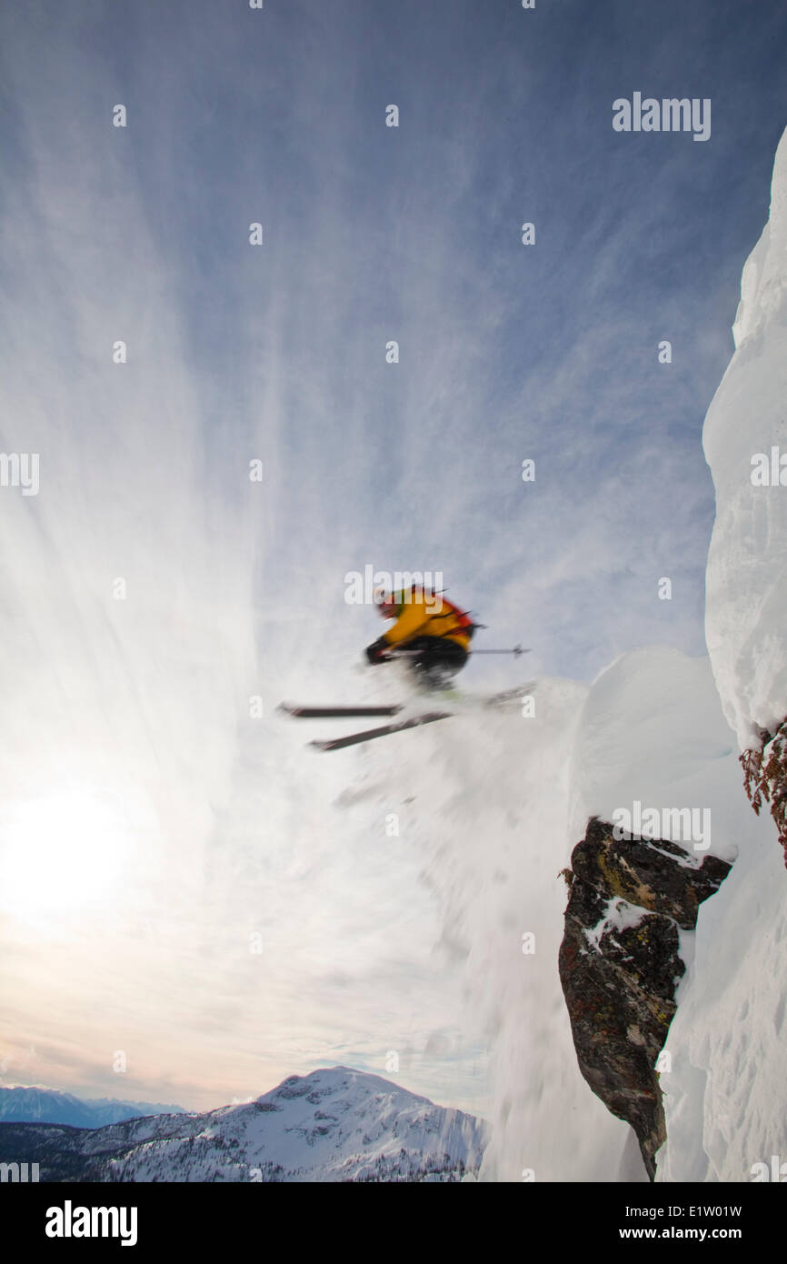 Un maschio di backcountry rider scende una scogliera mentre fuori lo sci alpinismo, Sol Mountain, Monashee Backcountry, Revelstoke, BC Foto Stock