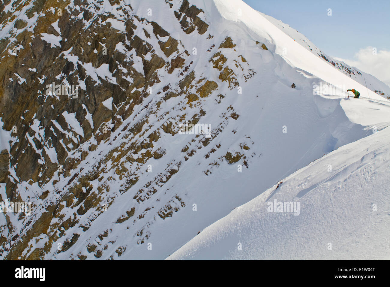 Un maschio di backcountry rider il taglio di un cornicione di fare alcune prove di pendenza prima di impegnare la linea di sci. Ghiacciaio Lodge, Golden, BC Foto Stock