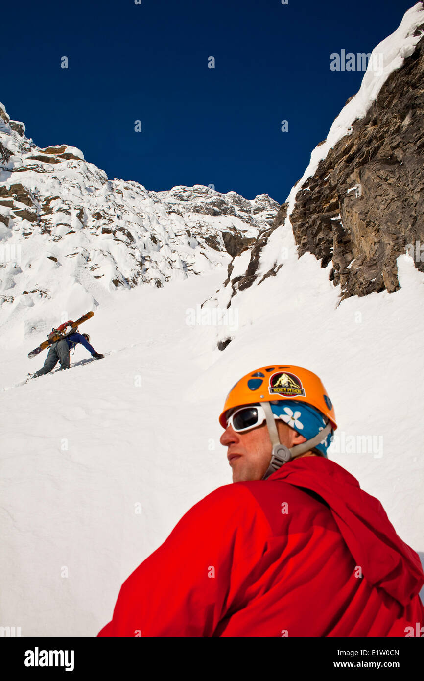 Due maschi sciatori backcountry bootpack su una ripida ed esposta coulior su Mt. Patterson, Icefields Parkway, Banff, AB Foto Stock