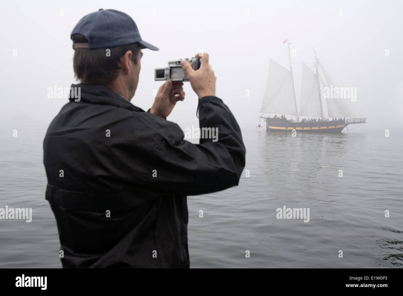 Un uomo fotografie nave a vela Liana il riscatto come si naviga in una fitta nebbia nel porto di Halifax durante il 2009 Tall Ships festival ho Foto Stock