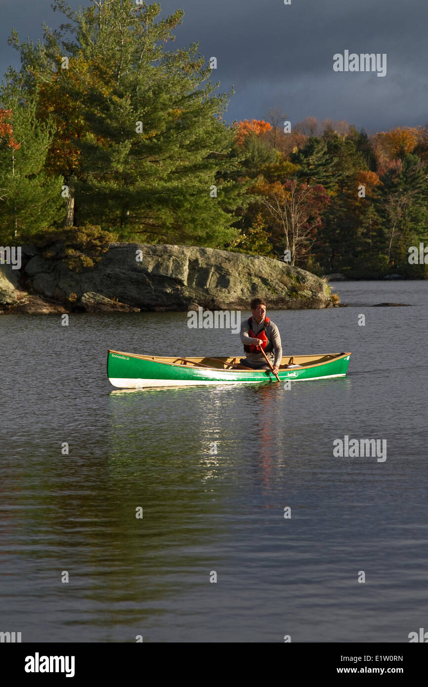 Giovane uomo canoa kayak sul lago Muskoka, Bracebridge, Muskoka, Ontario, Canada. Foto Stock
