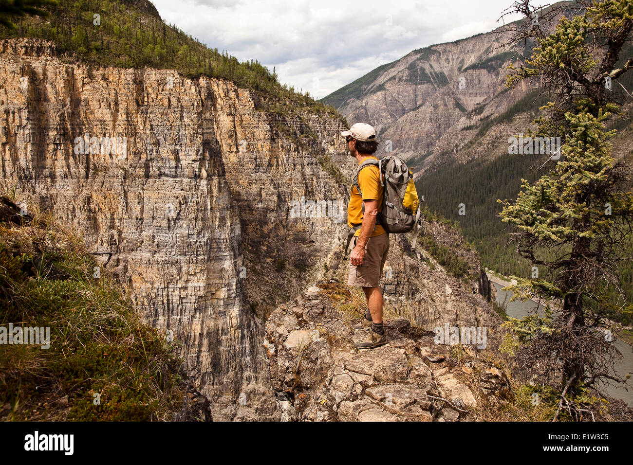 Uomo sulla scogliera sopra il fiume Nahanni vicino a 'Il Pulpito " formazione di roccia, Parco Nazionale Nahanni preservare, NWT, Canada. Foto Stock