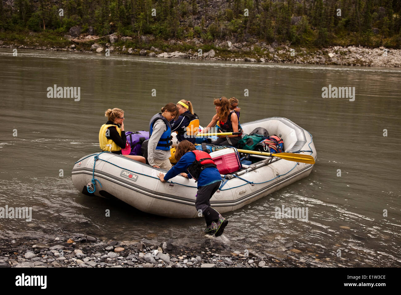 Ragazza giovane spinge zattera da riva sul fiume Nahanni, Parco Nazionale Nahanni preservare, NWT, Canada. Foto Stock