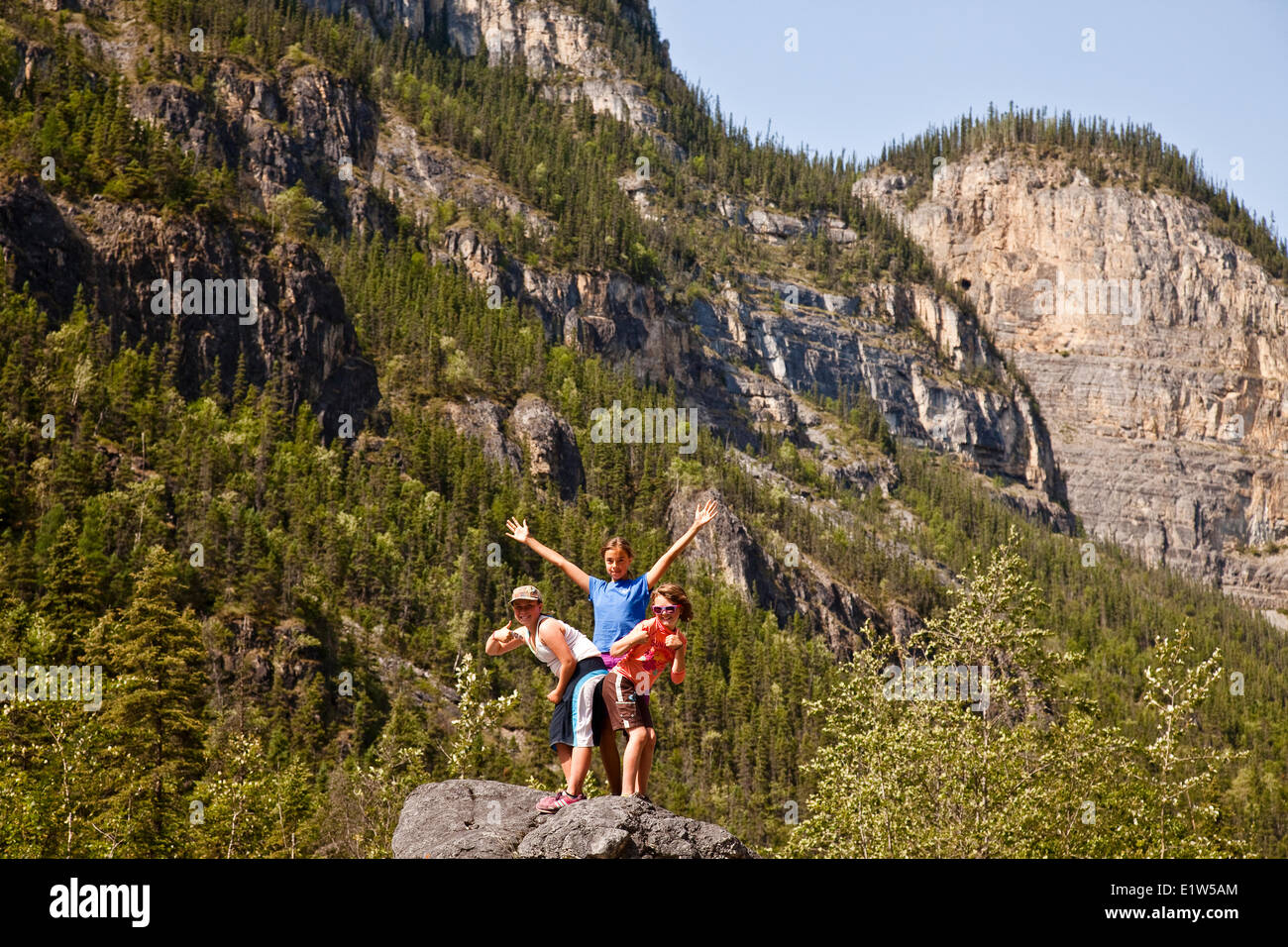 Le tre ragazze strike pongono mentre escursionismo fino Lafferty Creek sul fiume Nahanni, Parco Nazionale Nahanni preservare, NWT, Canada. Foto Stock
