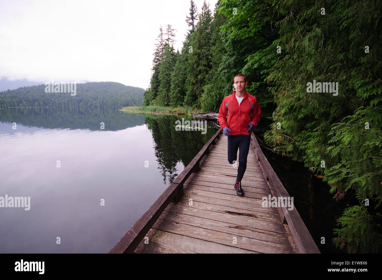 In esecuzione e trekking sul sentiero intorno al lago Sasamat, Belcarra Parco Regionale di Porto, Moody, British Columbia, Canada Foto Stock