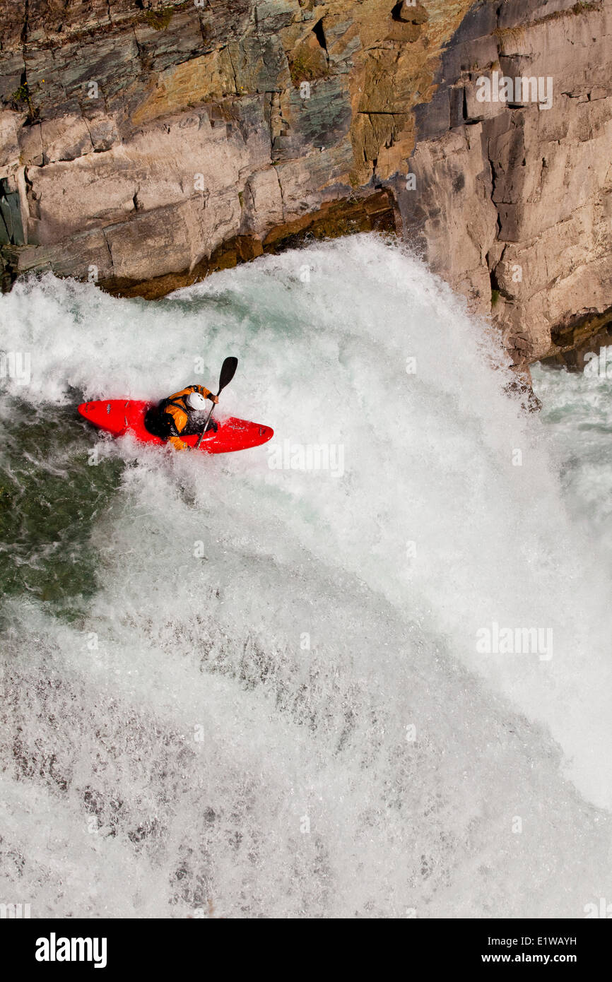Un maschio di kayaker corre salto di fede, 30 piedi di cascata sulla tomaia Elk River, Fernie, BC Foto Stock