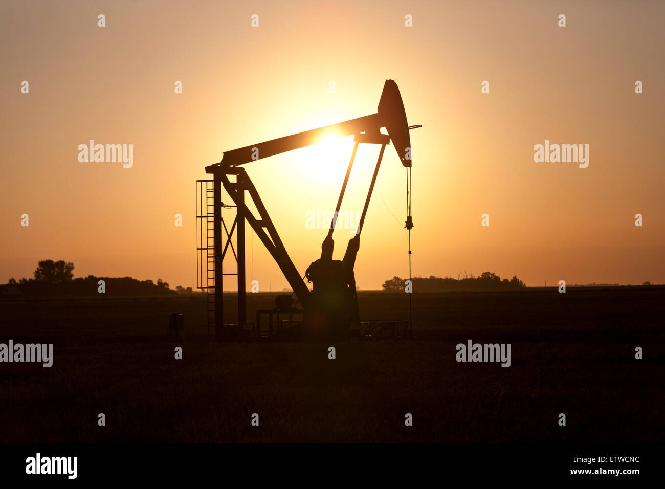 Olio pumpjack stagliano contro il Rising Sun nel sud di Manitoba in Canada Foto Stock