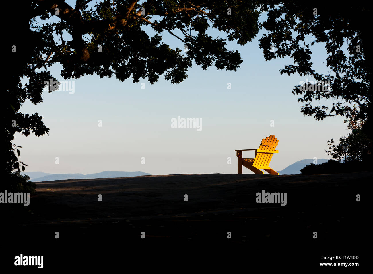 Una sedia adirondack incorniciata dagli alberi ti aspetta presso il punto giallo Lodge in cedro. Il Cedar Central Vancouver Island British Foto Stock