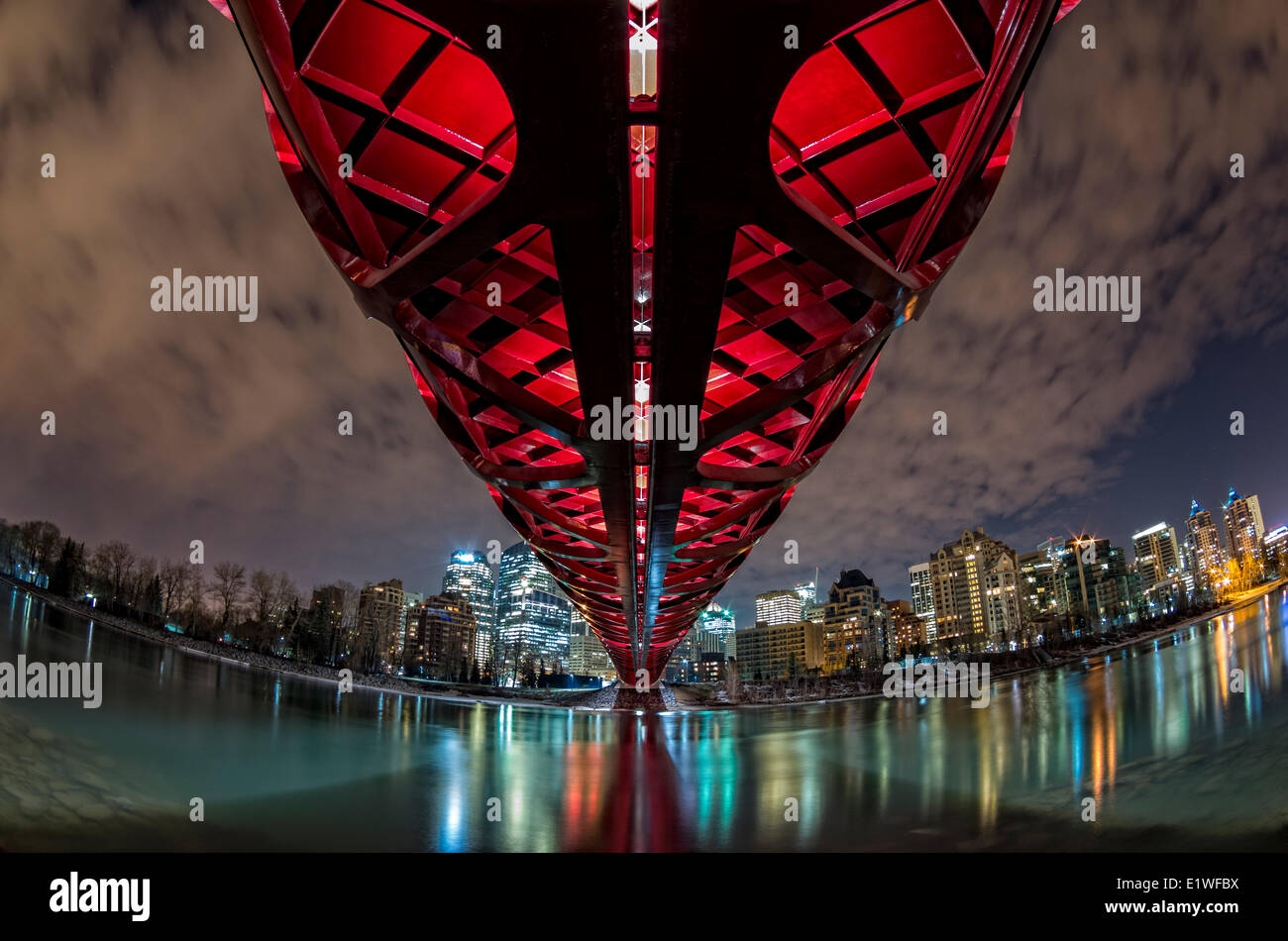 Pedonale ponte di pace e il centro cittadino di Calgary riflettente nel Fiume Bow di notte. Calgary, Alberta, Canada. Foto Stock