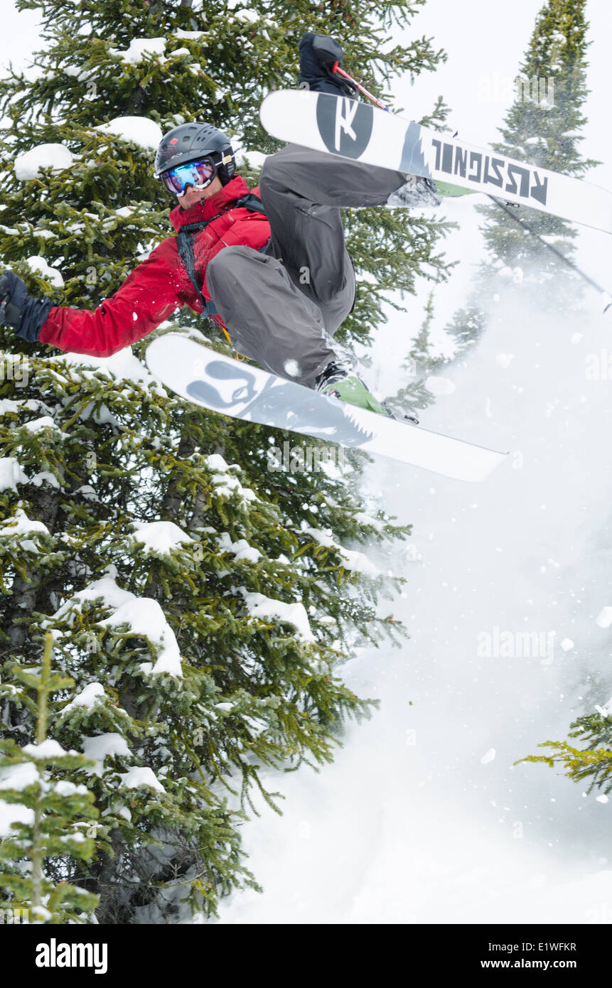 Un maschio di sciatore prende un salto di controllo durante la pratica dello sci in Kootenays, British Columbia Foto Stock