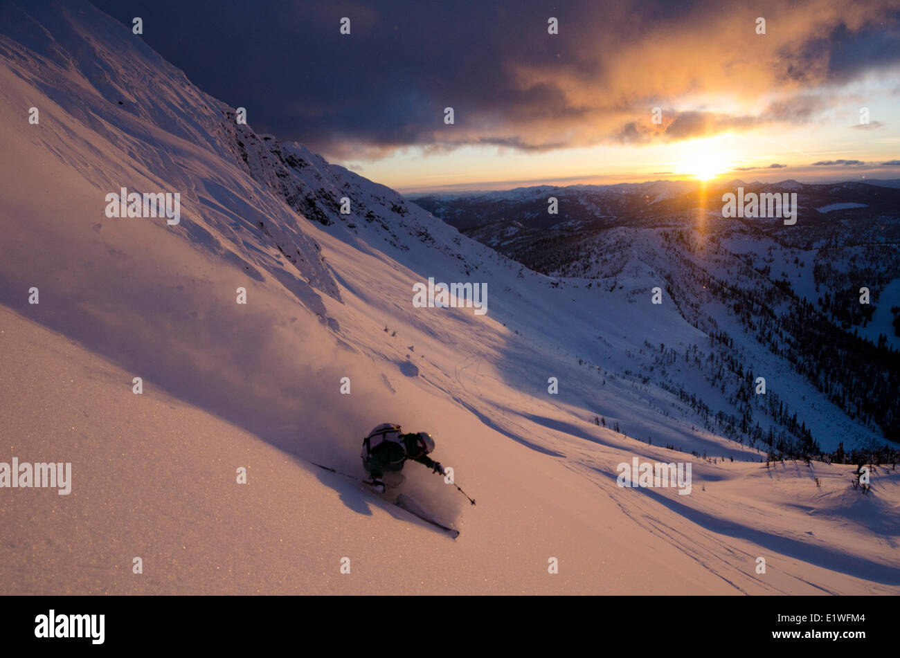 Una femmina di sciatore girando in seguito alpenglow Ymir picco nella Whitewater backcountry vicino a Nelson, British Columbia Foto Stock