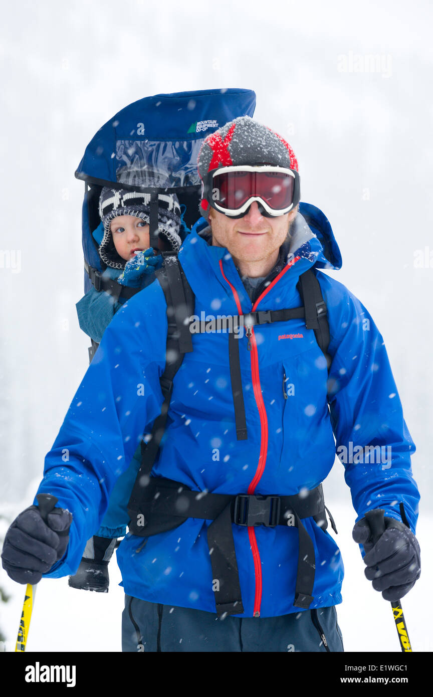 Un uomo e il suo giovane figlio godetevi una passeggiata nella neve, montagne Monashee, British Columbia Foto Stock