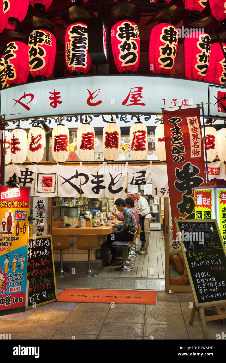 Piccolo ristorante con abbondanti di segnaletica in Osaka Shinsekai del distretto. Il quartiere è stato creato nel 1912 con New York come un m Foto Stock