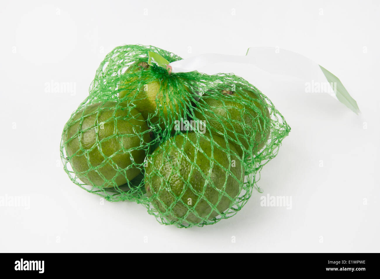 Quattro limette confezionato in un supermercato sacchetto di compensazione Foto Stock