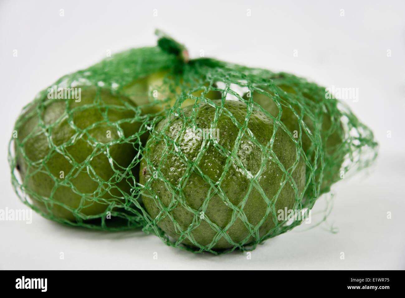 Quattro limette confezionato in un supermercato sacchetto di compensazione Foto Stock