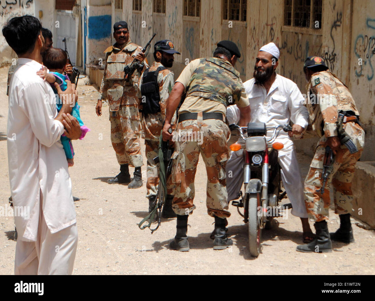 Di Karachi, Pakistan. Decimo Giugno, 2014. Di sicurezza pakistane personale a prendere un corpo di effettuare la ricerca vicino aeroporto di Karachi in Pakistan meridionale città portuale di Karachi il 10 giugno 2014. Le operazioni di volo presso l'aeroporto internazionale di Jinnah è stata sospesa a seguito di un attacco da parte di banditi sconosciuto in un aeroporto delle forze di sicurezza' campo in Pakistan meridionale della città portuale di Karachi nel pomeriggio di martedì i media locali hanno riferito. © Arshad/Xinhua/Alamy Live News Foto Stock