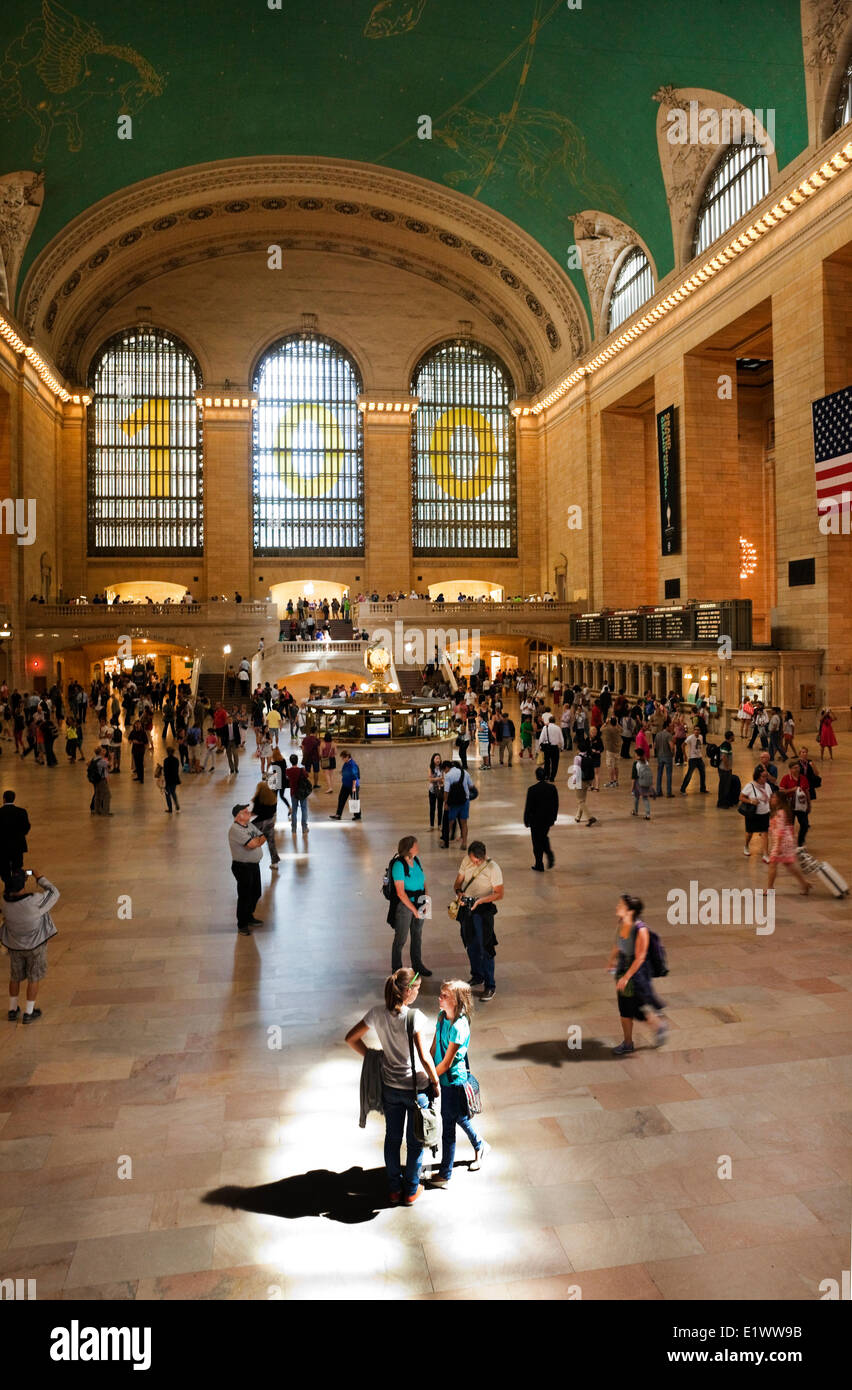 All'interno della spazio cavernoso di New York City's Grand Central Terminal, a madre e figlia sono illuminati uno stretto raggio di sole Foto Stock