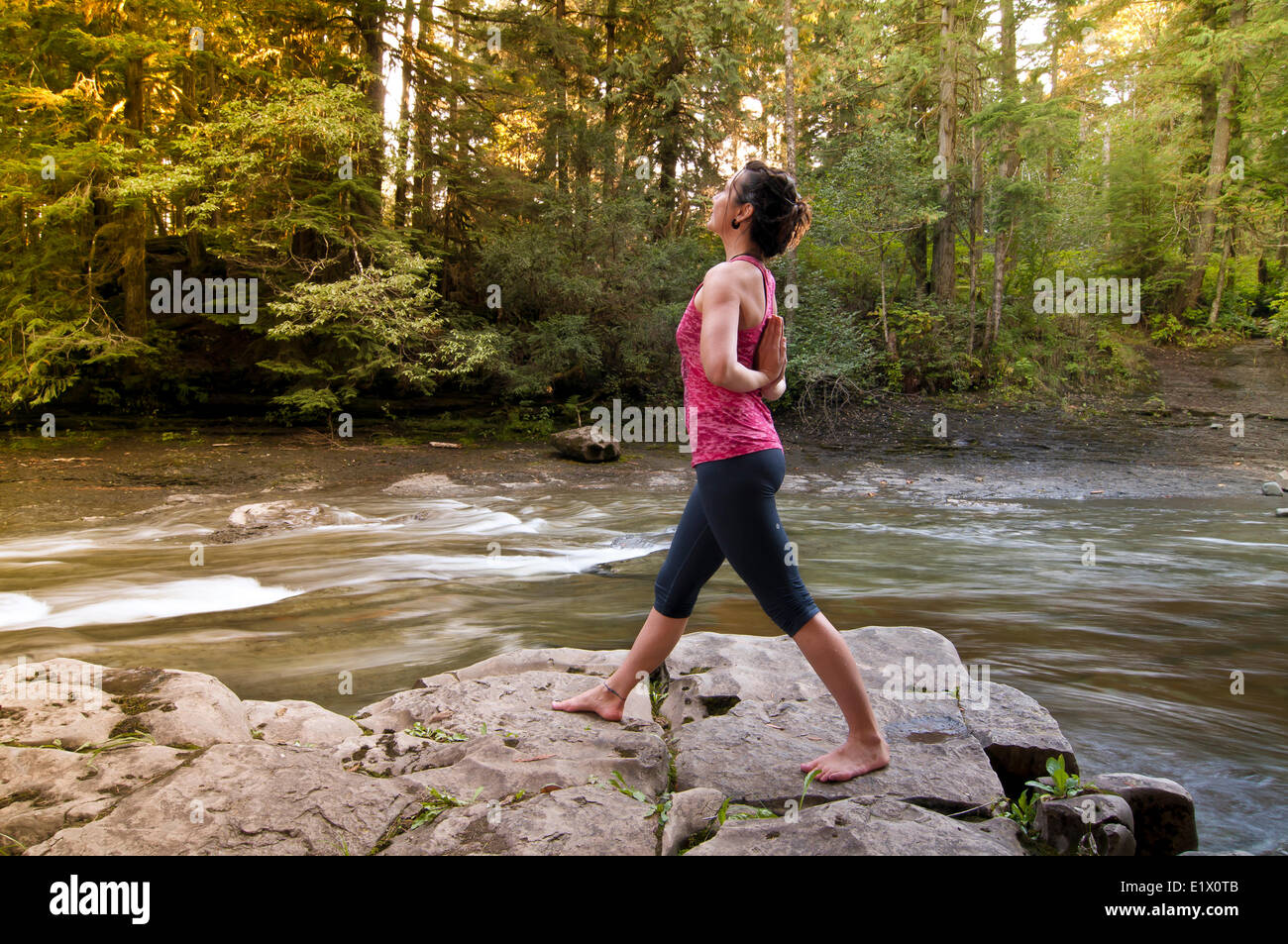 Una donna hodling una inversione di preghiera Yoga posa, Courtenay British Columbia, Canada Foto Stock