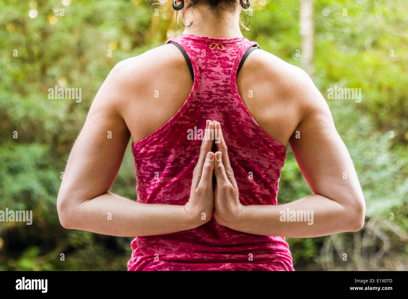 Una ragazza in un serbatoio di rosa hodling una inversione di preghiera Yoga posa, Courtenay British Columbia, Canada Foto Stock Una ragazza in un serbatoio di rosa hodling una inversione di preghiera Yoga posa, Courtenay British Columbia, Canada Foto Stock