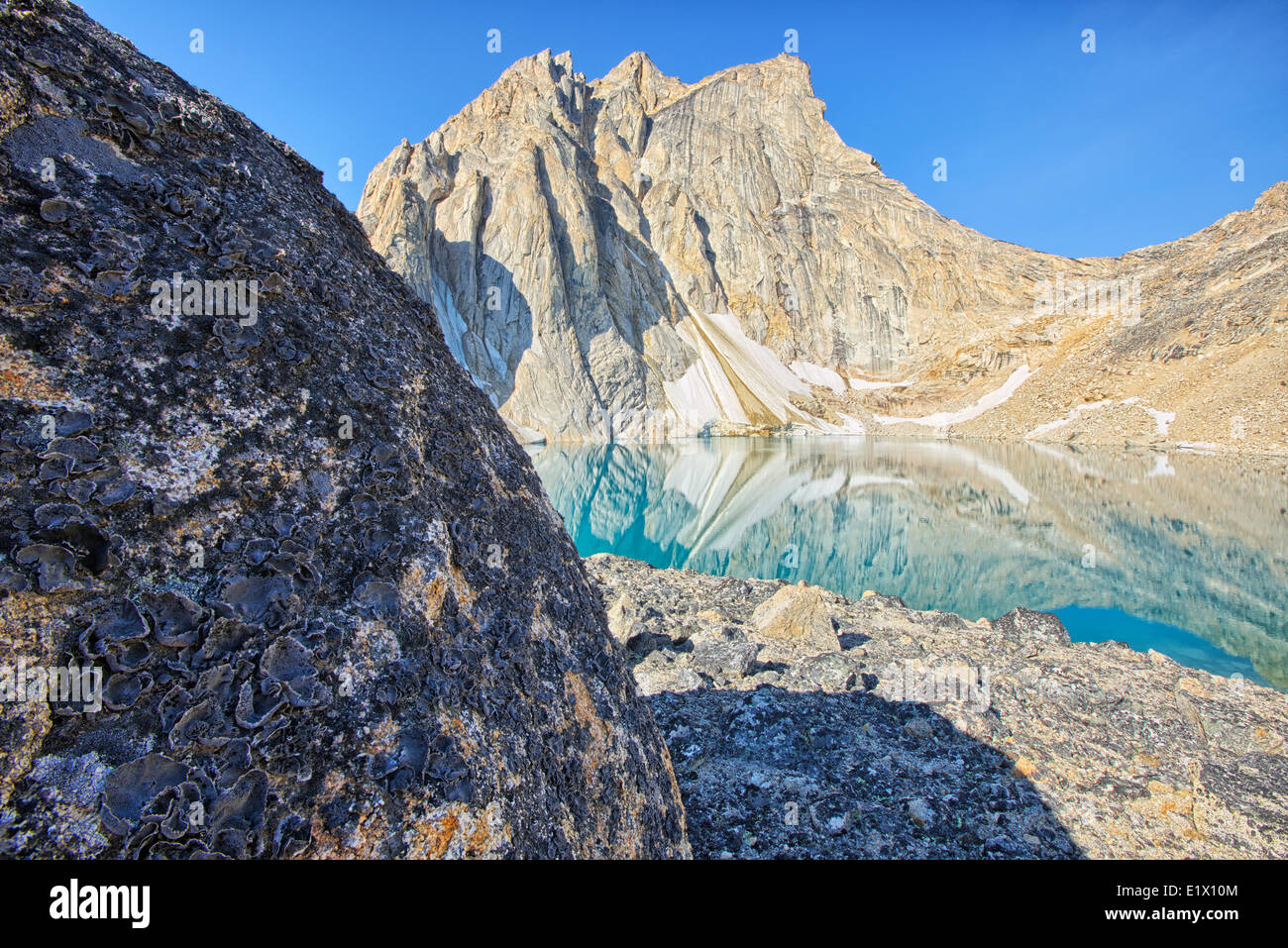 Un lago glaciale sorge alla base del picco Radalet nello Yukon Coast Mountains. Foto Stock