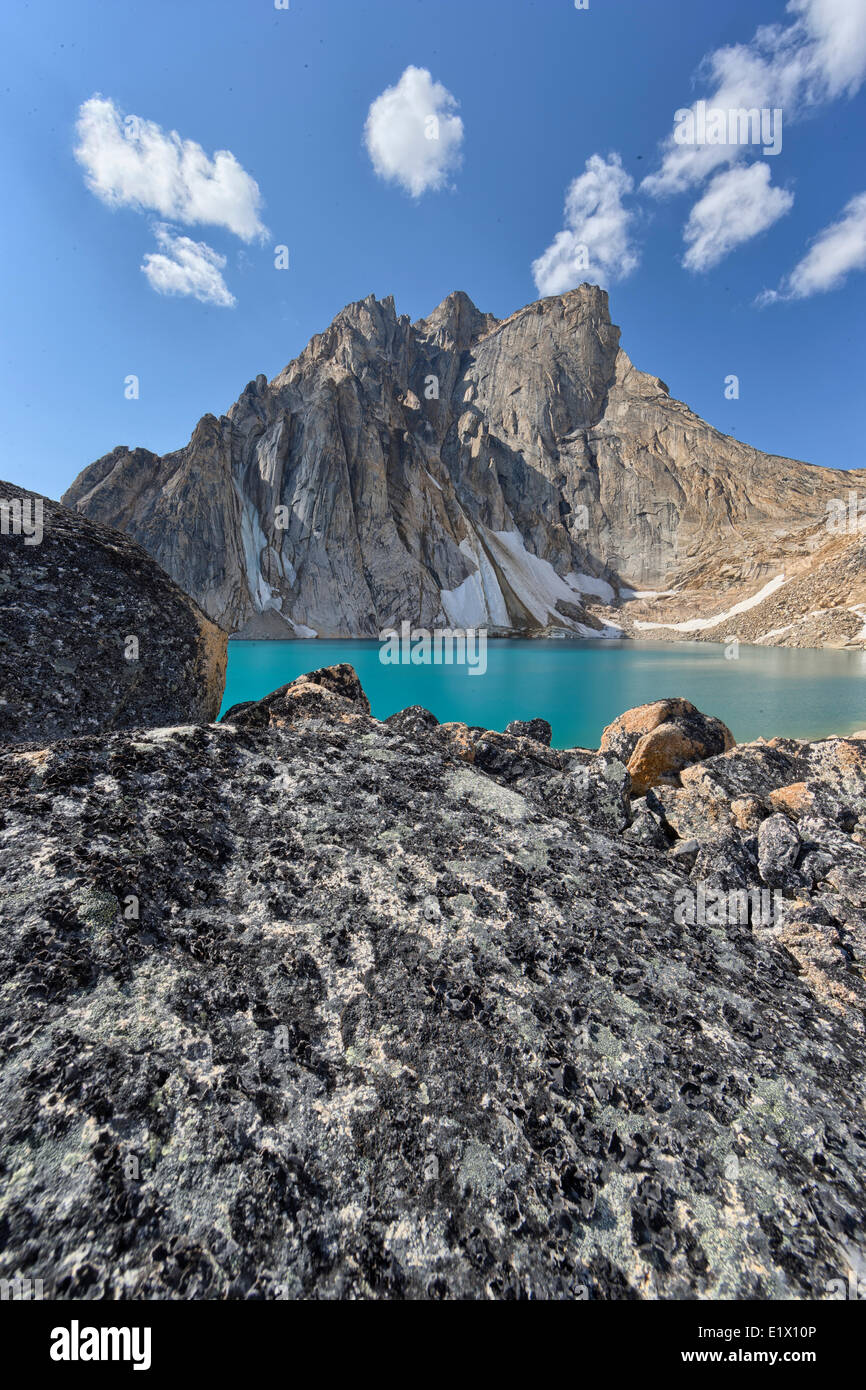 Un lago glaciale sorge alla base del picco Radalet nello Yukon Coast Mountains. Foto Stock