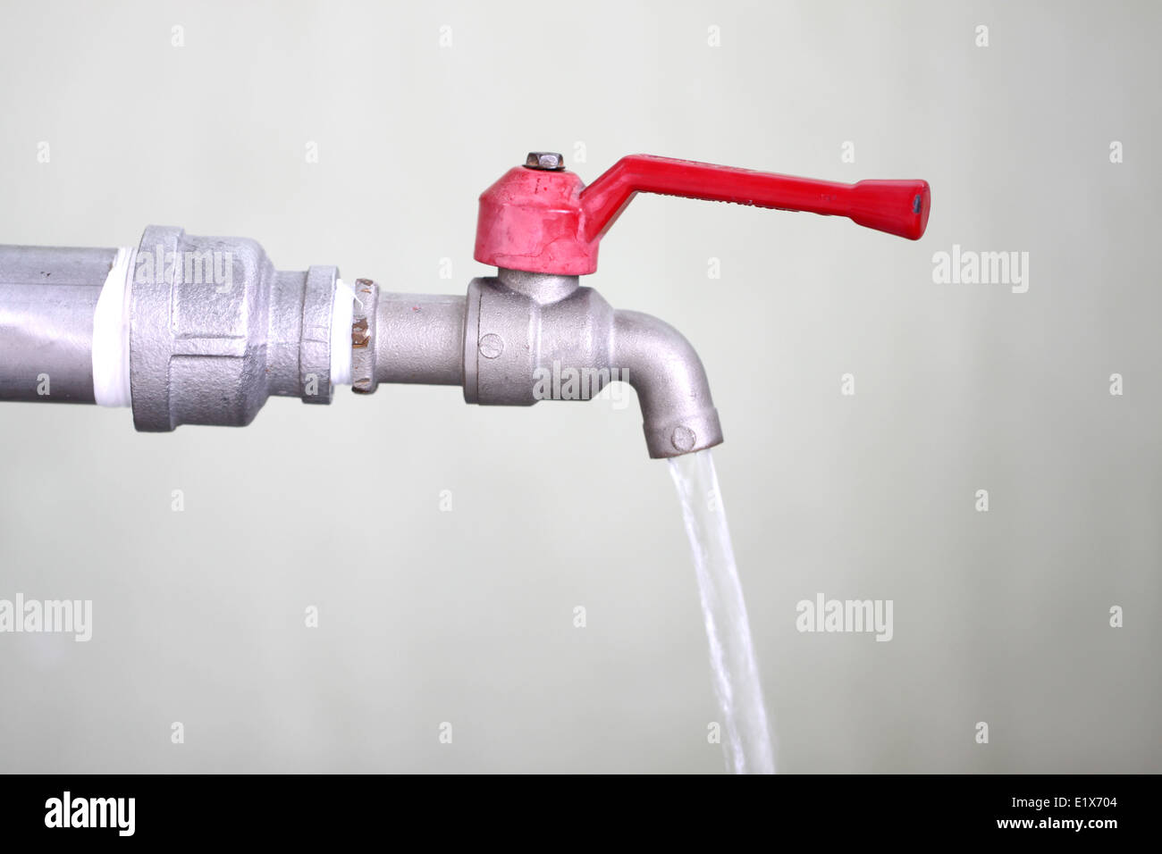 Rubinetto con acqua che scorre per lo sfondo. Foto Stock