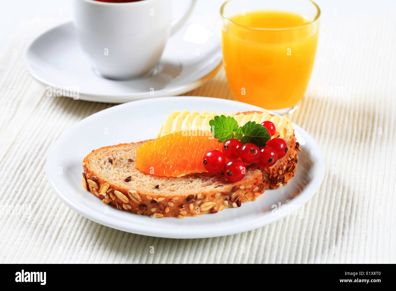 Pane con burro e frutta, tazza di tè e caffè e succo d'arancia Foto Stock